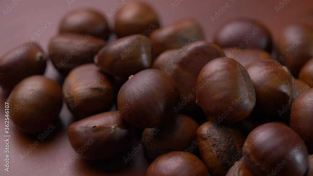 Close-up of chestnuts on wooden table in panning shot Close-up of chestnuts on wooden table in panning shot