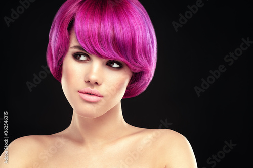 Beauty young woman portrait with Pink ombre hair style. Purple color dyed hair model portrait on black background.