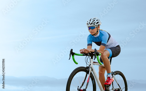 Young Woman Cyclist Riding Road Bike in the Beautiful Mountains. Adventure, Healthy Lifestyle, Sport