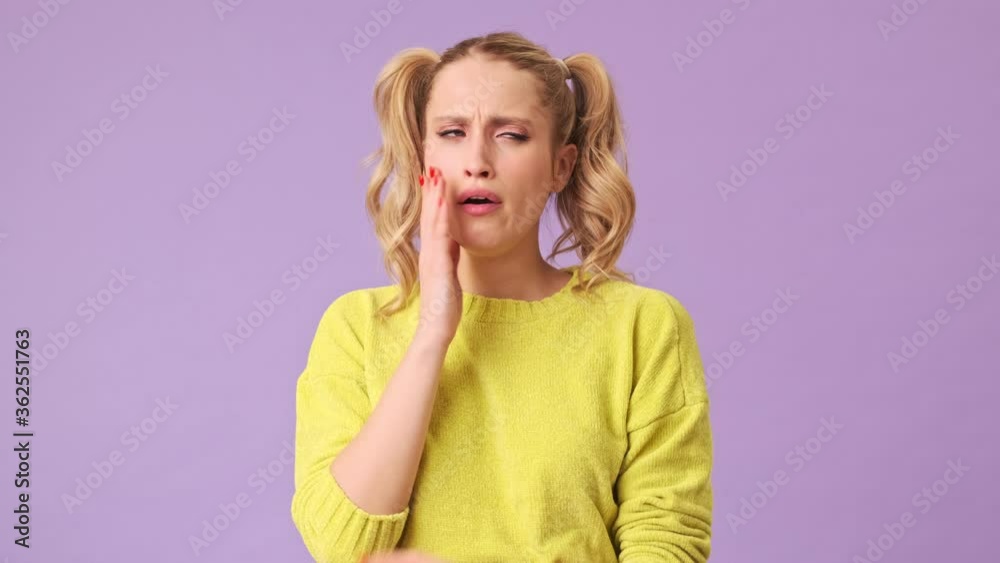 The beautiful blonde girl did not get enough sleep last night after the party and barely got up in the morning, yawning in an isolated studio on a purple background The beautiful blonde girl did not get enough sleep last night after the party and barely got up in the morning, yawning in an isolated studio on a purple background