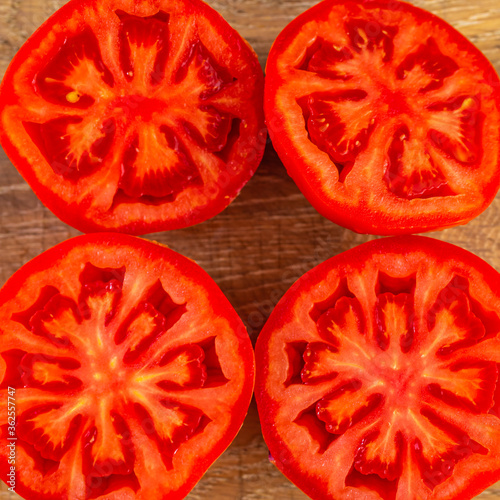 Ripe, sliced tomatoes on a wooden board.