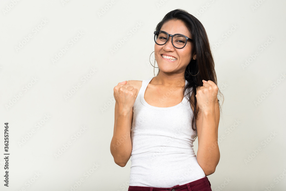 Portrait of happy Asian nerd woman getting good news Portrait of happy Asian nerd woman getting good news