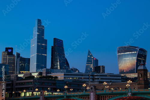 Cityscape in blue hours, 20 Fenchurch Street Walkie Talkie building and 122 Leadenhall Street Cheesegrater Building  reflecting the sun and the skyscrapers.  Photo taken from the South Bank photo