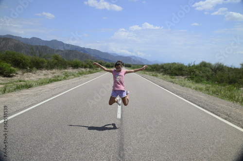 Chica sola saltando alegre en la ruta © Joaquin