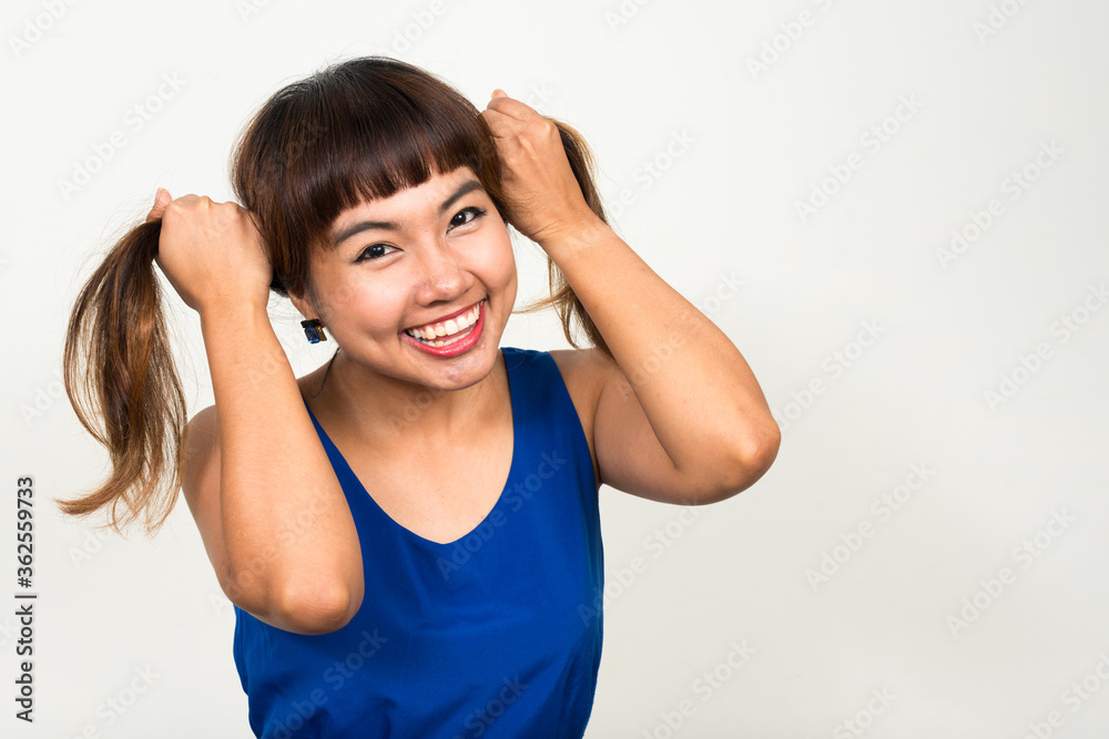 Portrait of happy young beautiful Asian woman playing with hair Portrait of happy young beautiful Asian woman playing with hair