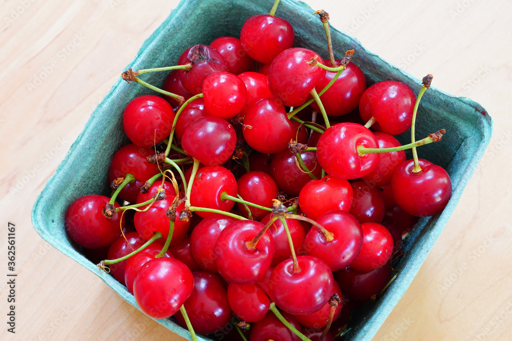 Container of fresh red sour cherries at a farmers market Container of fresh red sour cherries at a farmers market