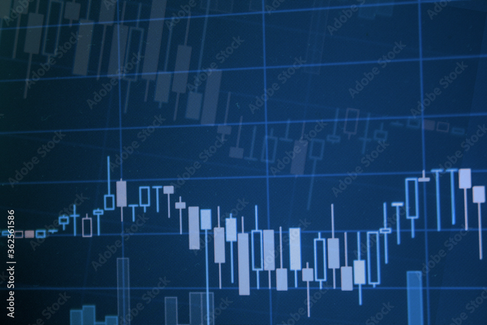Closeup financial stock chart with uptrend line candlestick graph in stock market on blue color monitor
