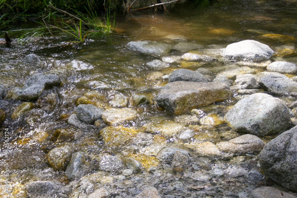 Mountain stream river with many rock stone. Natural outdoor flowing river background. Mountain stream river with many rock stone. Natural outdoor flowing river background.