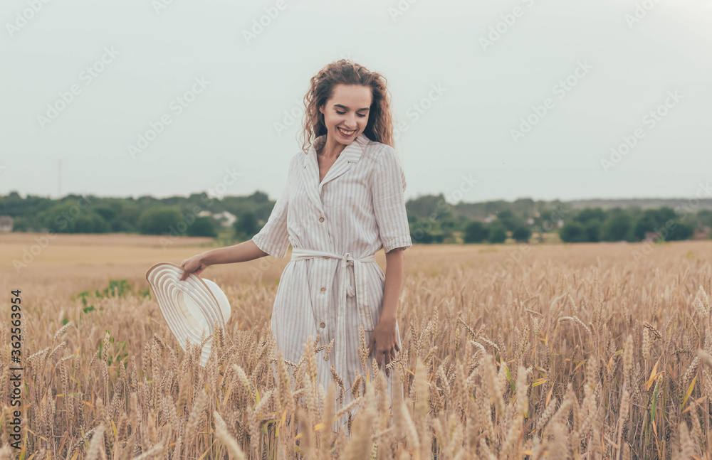 Girl puts a hat on a wheat field, girl plays with her hat on a field
Girl puts a hat on a wheat field, girl plays with her hat on a field