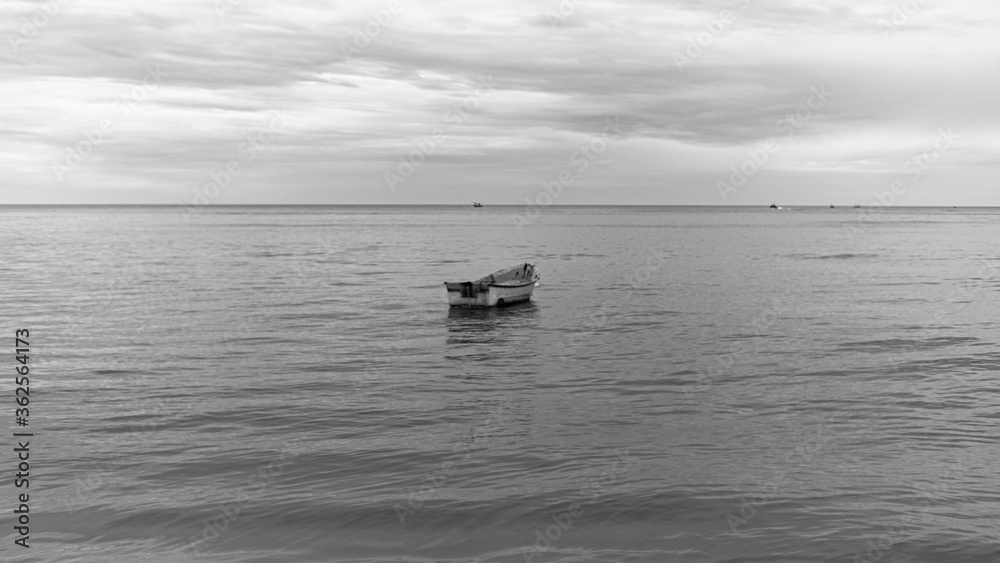 a boat on the sea at Hua Hin beach Thailand with view in Black and white colors