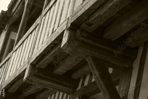 Half timbered house balcony. Detail of a building. France. Old buildings conservation and restoration, European heritage concepts. Sepia photo.