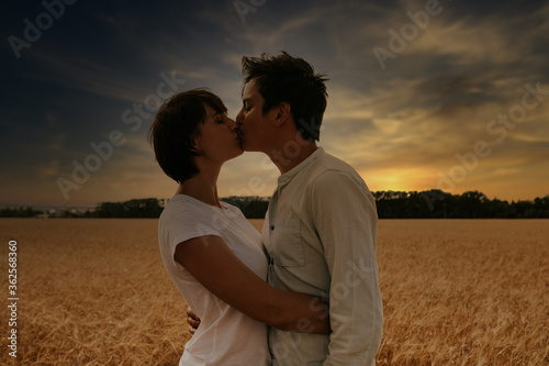 portrait of a couple kissing in a wheat field under a sunset © kevin