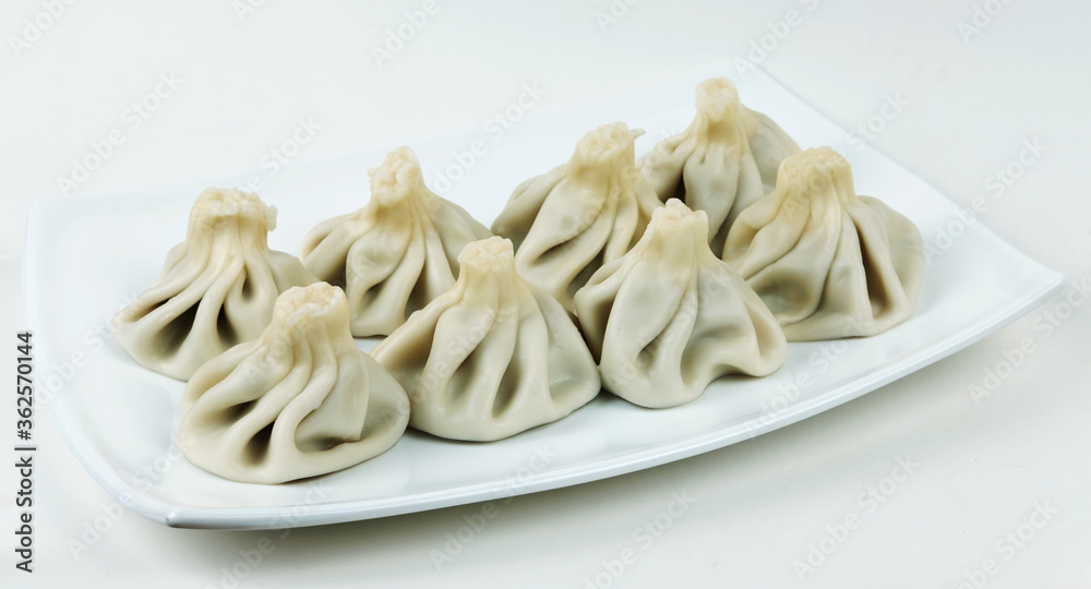 Boiled khinkalis (Georgian dumpling) on a white plate