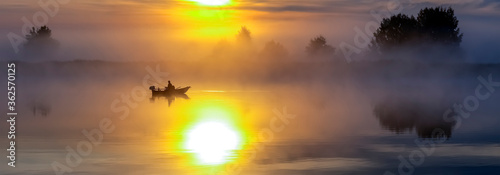Fishing boat at sunrise over the river
