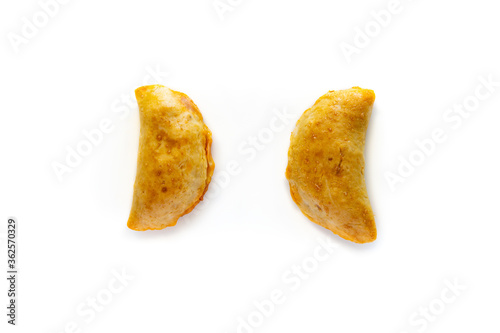 Two homemade freshly baked empanadas pastry with meat filling a gluten-free version of an authentic traditional Spanish Latin America cuisine food isolated on white background.