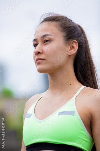 Cute girl fitness instructor posing on online workout outside, photography for blog or ad of sport and healthy lifestyle