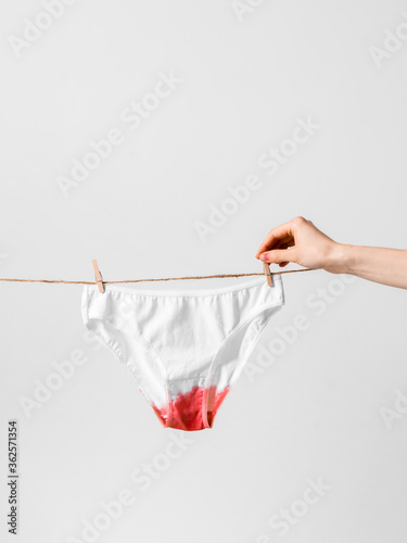Woman hangs underwear on clothesline, concept content for feminist blog, poster about women's health and menstruation photo
