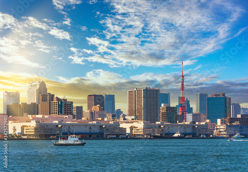 Photography Japanese tugboats sailing in front of the Hinode pier on Tokyo port with the skyscrapers of Shiba district and the Tokyo Tower in the back under sunset sky