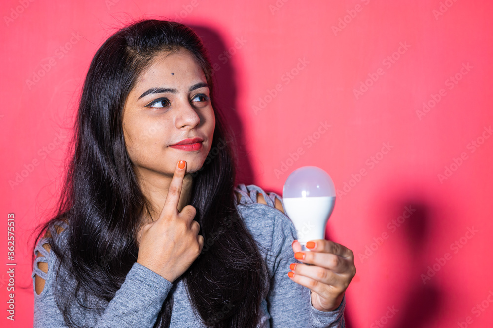 Pretty young woman holding a luminous led light bulb. Green energy , saving of energy with led bulb. Pretty young woman holding a luminous led light bulb. Green energy , saving of energy with led bulb.