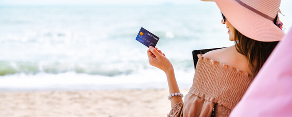 Summer traveler asian woman with credit card mockup travel in beach cafe Thailand