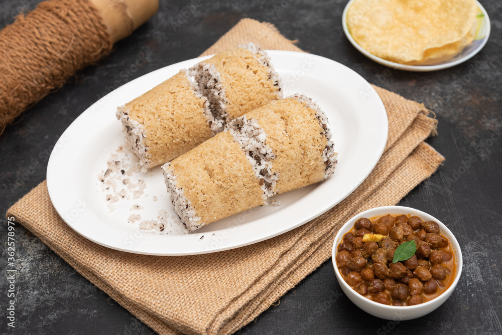 Popular South Indian breakfast puttu / pittu made of Wheat flour and coconut in a bamboo mould, with banana, Kerala, India. Bamboo puttu prepared in the bamboo utensil. Popular South Indian breakfast puttu / pittu made of Wheat flour and coconut in a bamboo mould, with banana, Kerala, India. Bamboo puttu prepared in the bamboo utensil.