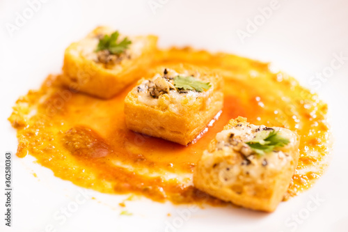 Grilled puff pastry topped with cheddar cheese & garlic butter, oregano seasoning & cilantro for garnish.