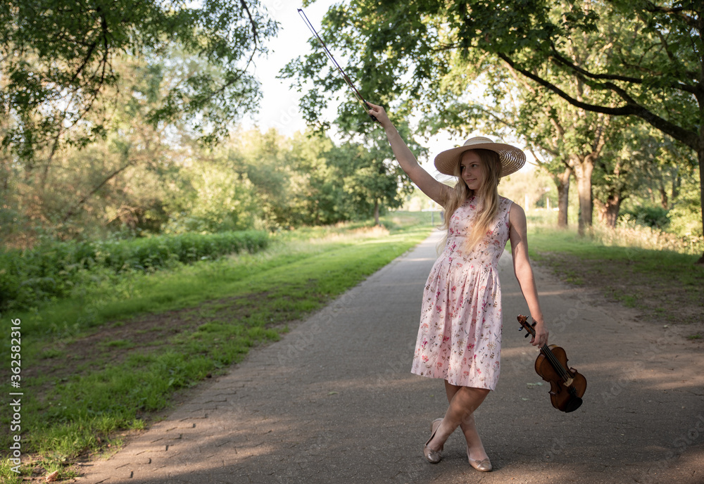 Eine junge Frau mit Violine im Park