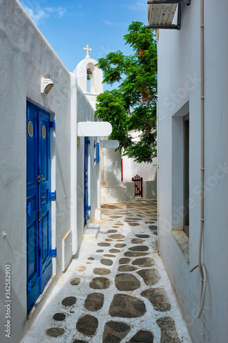 Fototapeta Naklejka Na Ścianę i Meble -  Picturesque scenic narrow Greek streets with traditional whitewashed houses with blue doors windows of Mykonos town in famous tourist attraction Mykonos island, Greece
