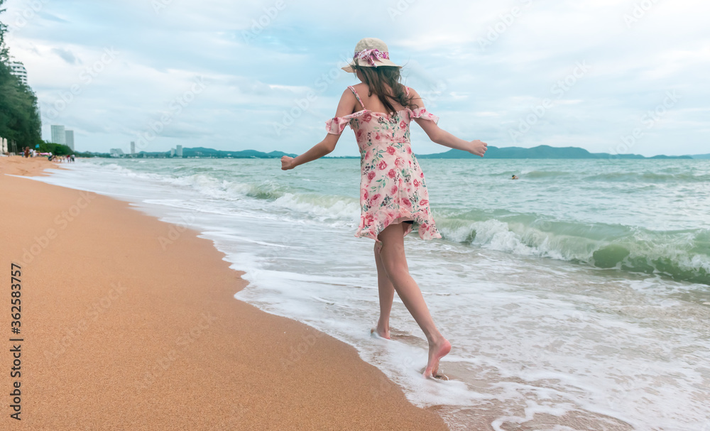 Asian traveler woman walking on the beach.

