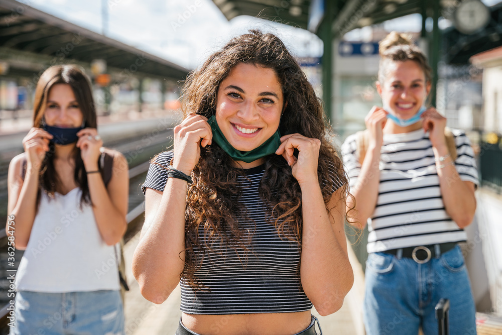 Portrait of a group of young millennial friends lower the mask and smile -Tools need to wearing avoid the infection from Coronavirus, Covid-19 - People having fun together - Concept of freedom Portrait of a group of young millennial friends lower the mask and smile -Tools need to wearing avoid the infection from Coronavirus, Covid-19 - People having fun together - Concept of freedom