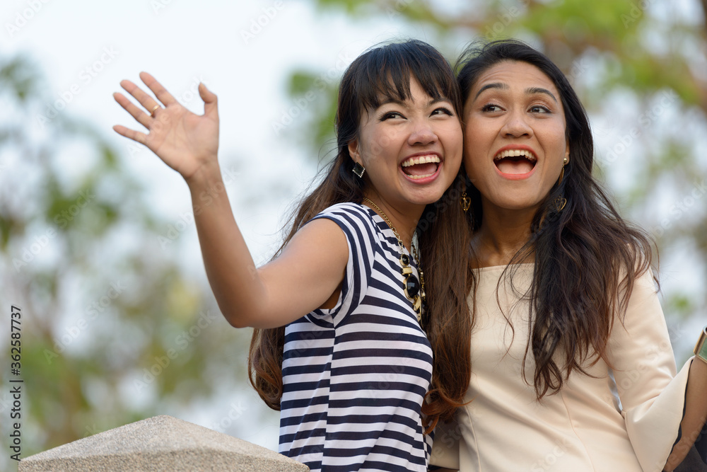Portrait of two happy young Asian women together at the park Portrait of two happy young Asian women together at the park