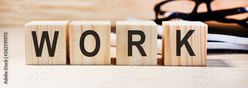 Inscription on wooden cubes Work on a table with glasses. The concept of working from home.