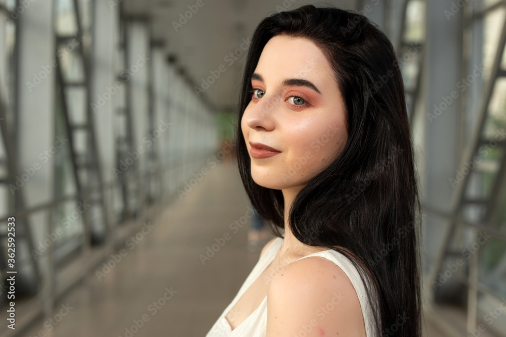 Portrait of a beautiful brunette in a light dress on the street in a pedestrian crossing on a summer day Portrait of a beautiful brunette in a light dress on the street in a pedestrian crossing on a summer day