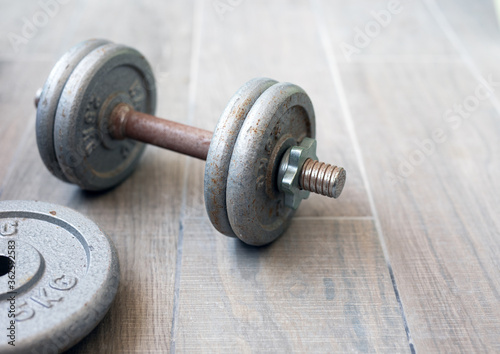 Old rusty dumbbells without use on a gray background