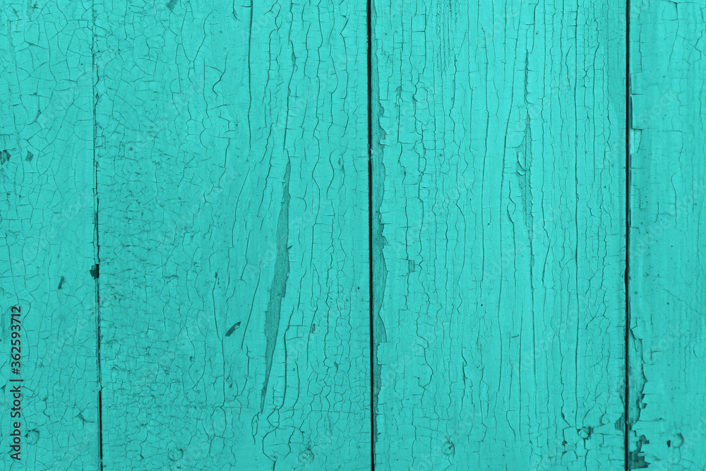 Background from turquoise painted old boards with cracked paint. Old rustic texture in a fashionable modern color. Background from turquoise painted old boards with cracked paint. Old rustic texture in a fashionable modern color.
