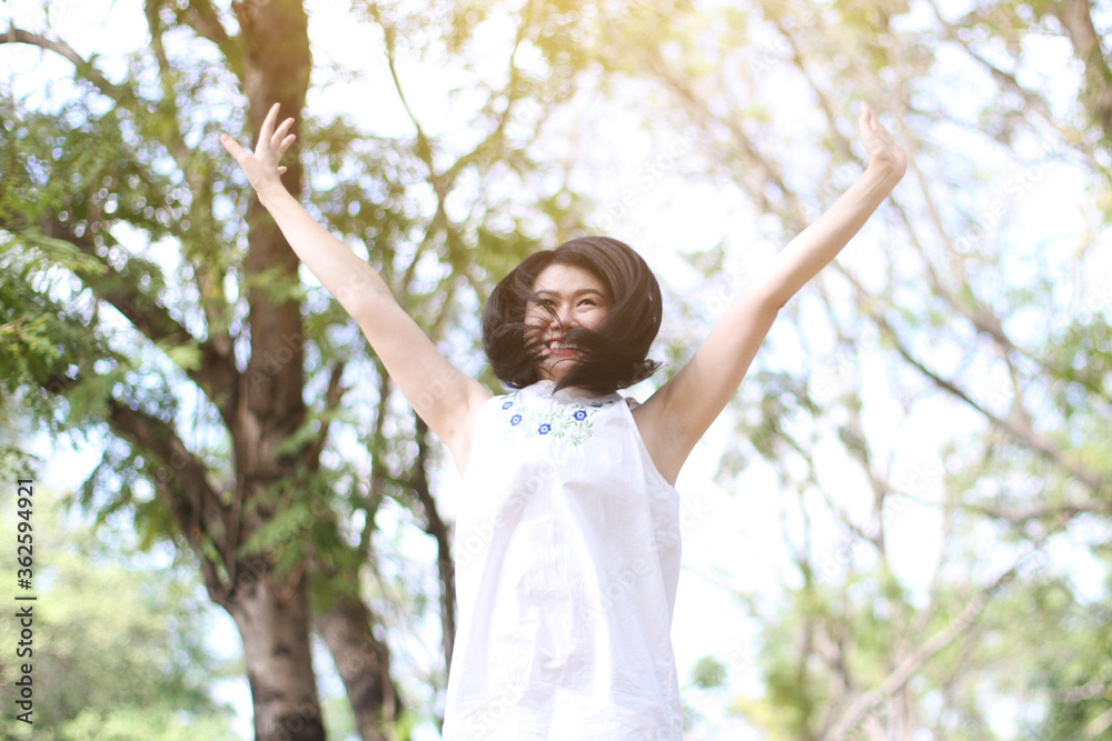 Beautiful asian woman in white dress relax and jumping with smile in the air at natural park. Thai girl or Chinese Girl enjoy on holiday. Freedom Concept Beautiful asian woman in white dress relax and jumping with smile in the air at natural park. Thai girl or Chinese Girl enjoy on holiday. Freedom Concept