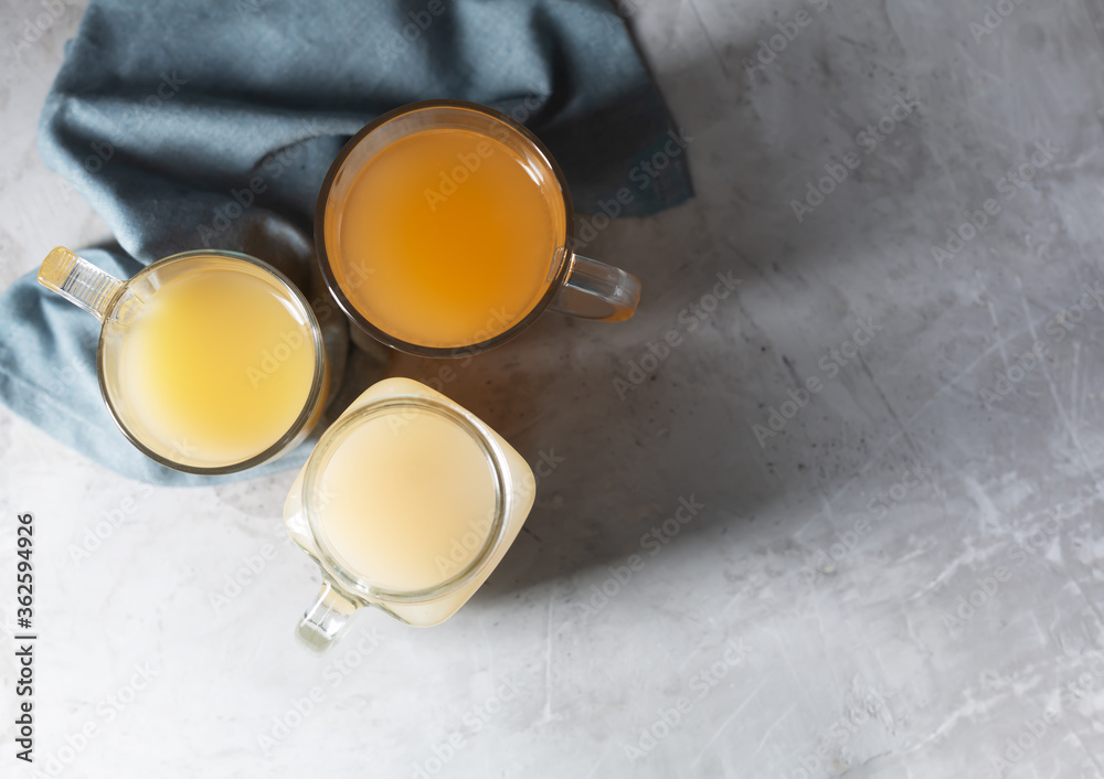 Homemade Beef Bone Broth in Glasses on a gray concrete background, top view with copy space Homemade Beef Bone Broth in Glasses on a gray concrete background, top view with copy space