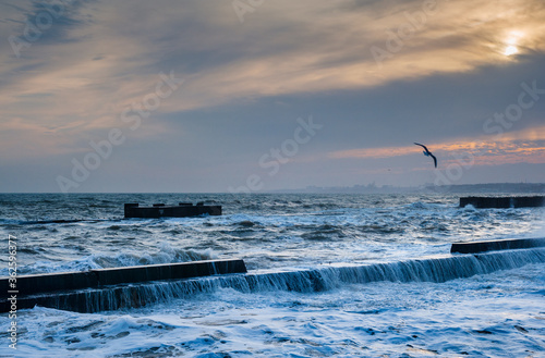 Stormy sea water running over the breakwater. Seascape