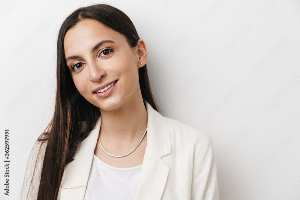Photo of young pleased businesswoman smiling and looking at camera Photo of young pleased businesswoman smiling and looking at camera