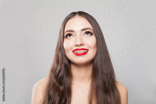 Healthy woman with braces on teeth on white background