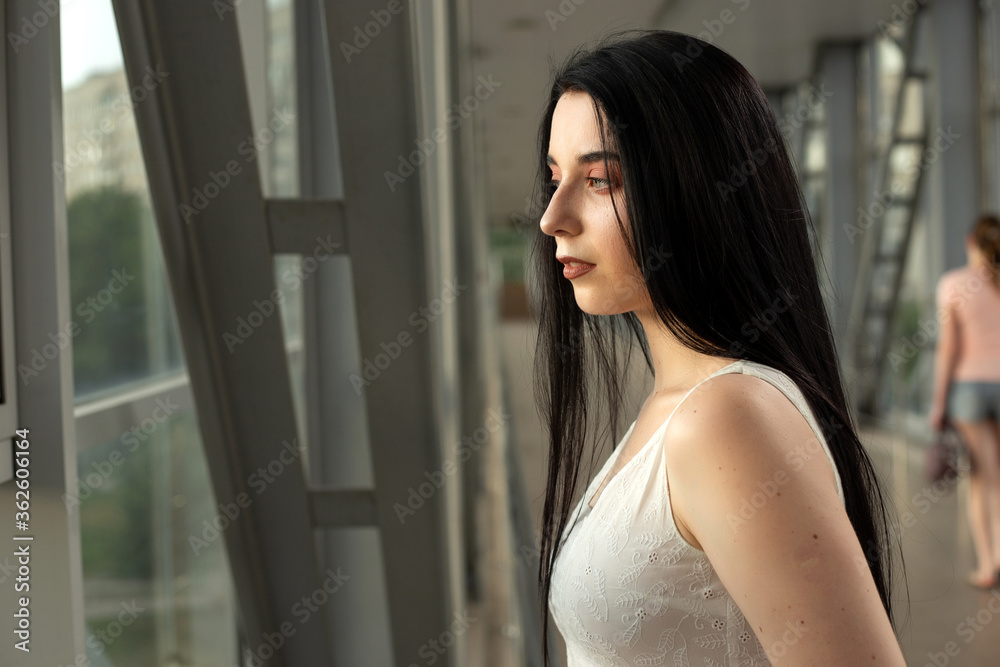 Portrait of a beautiful brunette in a light dress on the street in a pedestrian crossing on a summer day Portrait of a beautiful brunette in a light dress on the street in a pedestrian crossing on a summer day