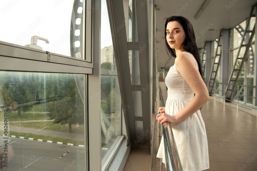 Portrait of a beautiful brunette in a light dress on the street in a pedestrian crossing on a summer day Portrait of a beautiful brunette in a light dress on the street in a pedestrian crossing on a summer day