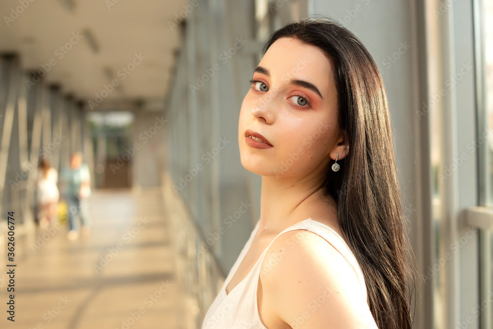 Portrait of a beautiful brunette in a light dress on the street in a pedestrian crossing on a summer day Portrait of a beautiful brunette in a light dress on the street in a pedestrian crossing on a summer day