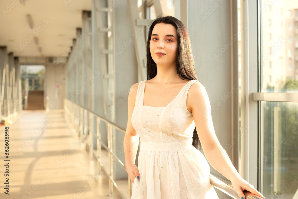 Portrait of a beautiful brunette in a light dress on the street in a pedestrian crossing on a summer day Portrait of a beautiful brunette in a light dress on the street in a pedestrian crossing on a summer day