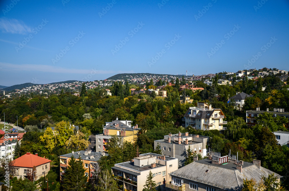 Aerial view of residential area buildings and forested hills of the Miskolc city in the north of Hungary at sunny summer day