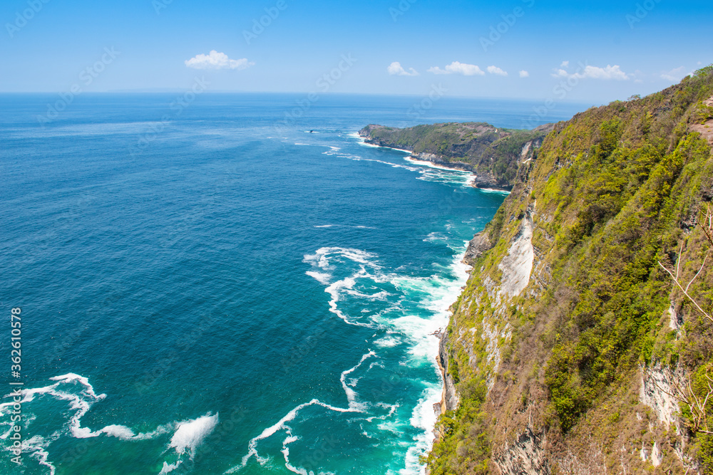 A horizon landscape of Kelingking beach sea shore green-aqua water wave from the top during the touristic visit in Nusa penida