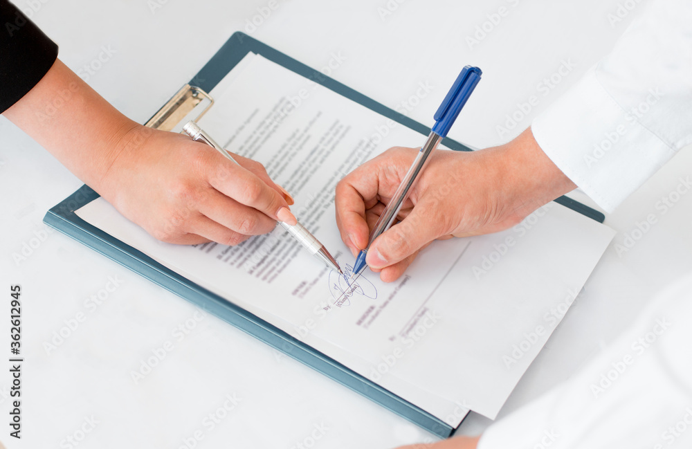 Close-up of hands signing contract agreement