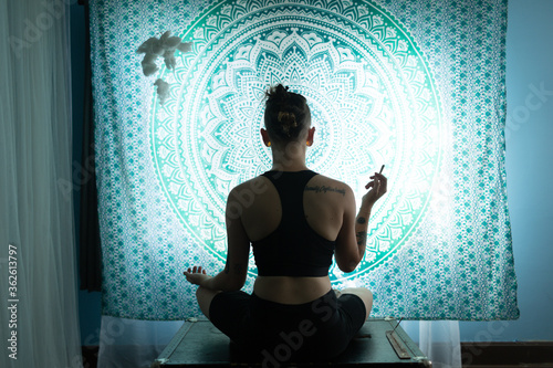 Young person smoking weed and doing yoga 