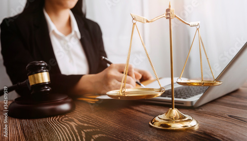 Business and lawyers discussing contract papers with brass scale on desk in office. Law, legal services, advice, justice and law concept picture with film grain effect