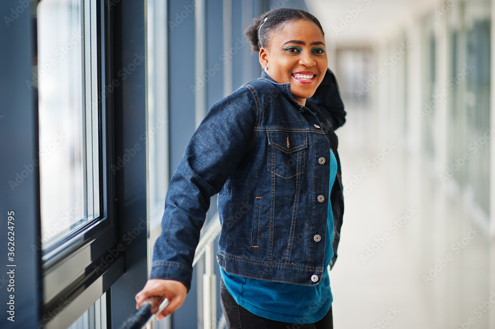 African woman in jeans jacket posed indoor. African woman in jeans jacket posed indoor.
